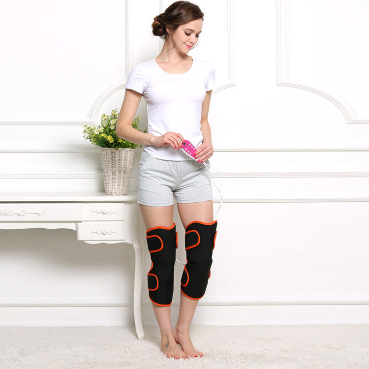 Woman using black and orange knee massager with remote control at home